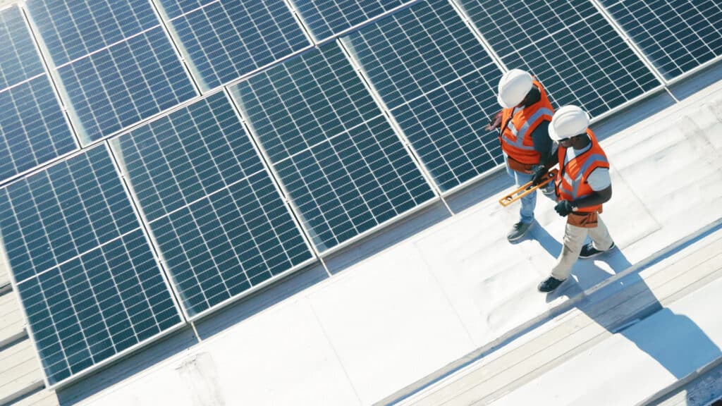 Commercial Solar Panels in Colorado Springs Feature Image: Two technicians on roof inspecting commercial solar system